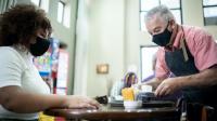 photo of a waiter serving coffee to a diner from Getty Images